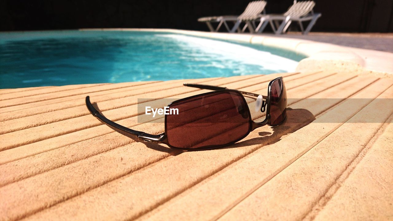 Close-up of sunglasses on table by swimming pool