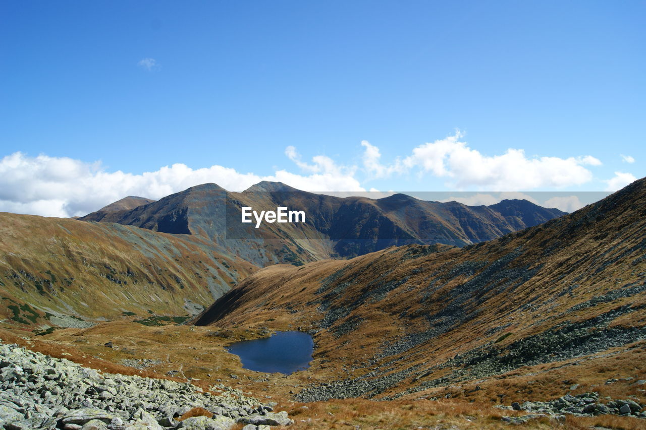 Scenic view of mountains against blue sky