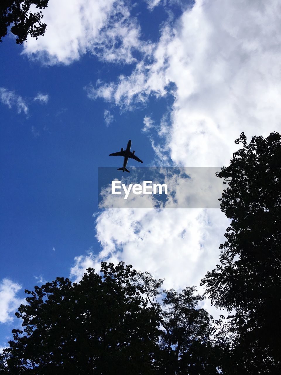 LOW ANGLE VIEW OF SILHOUETTE AIRPLANE FLYING AGAINST SKY