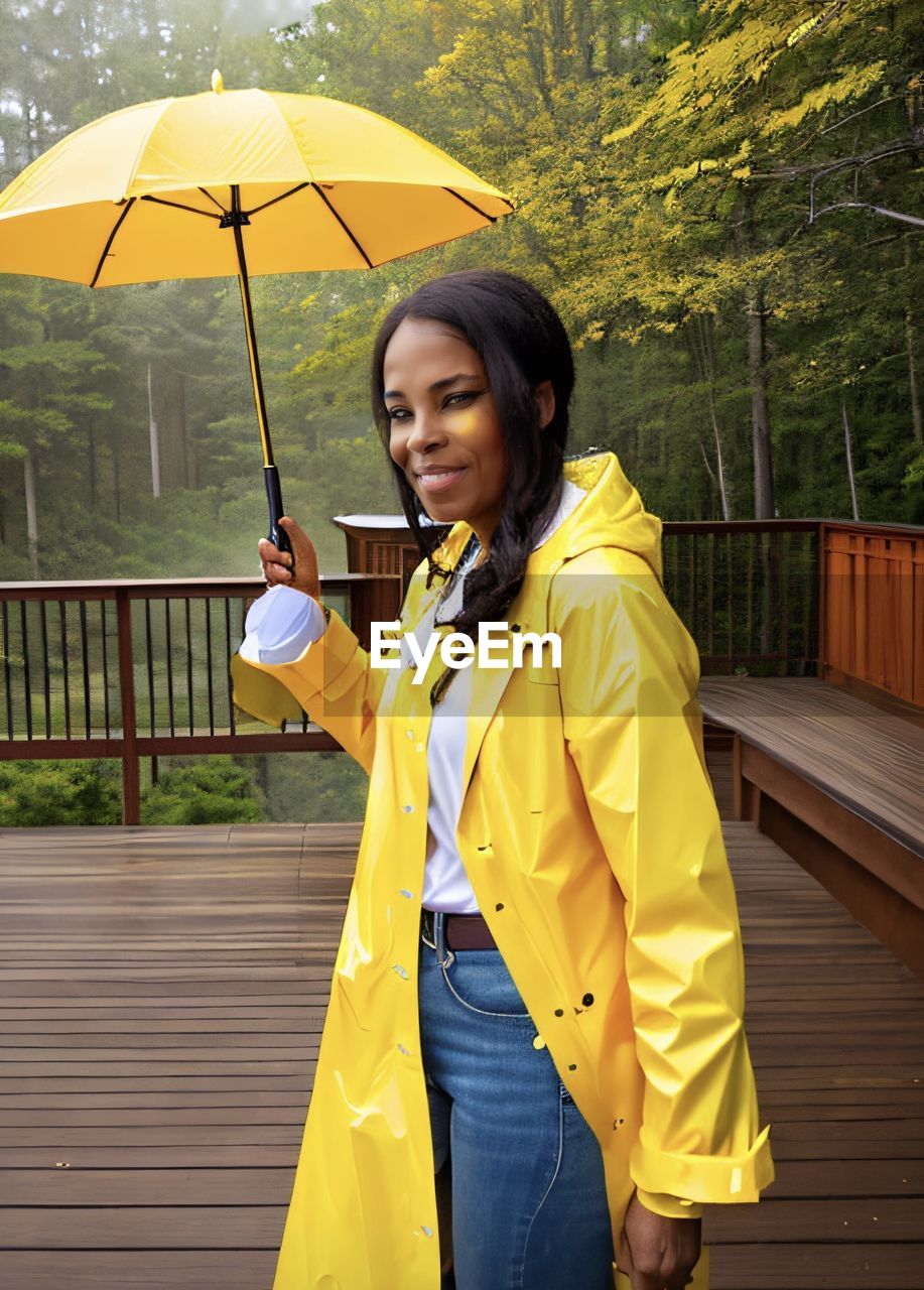 portrait of smiling young woman holding umbrella