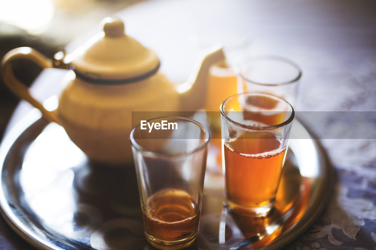 Close-up of tea in glasses by pot on tray