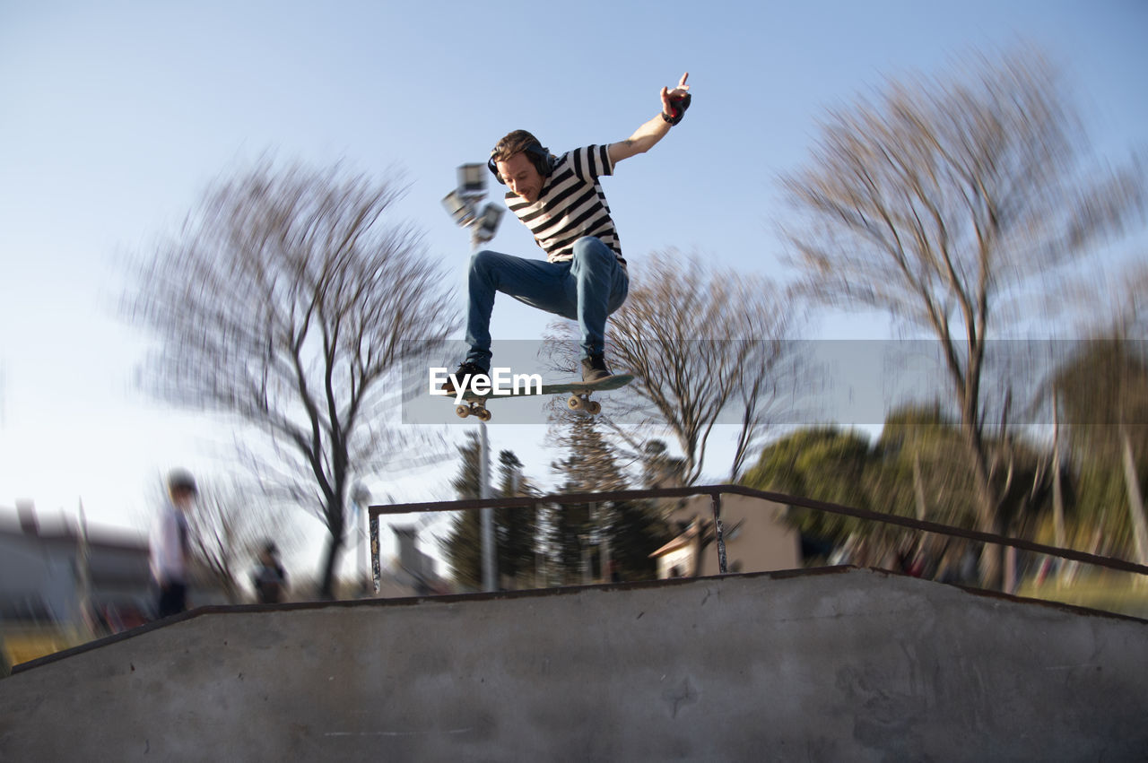 Portrait of skateboarder jumping with a ramp