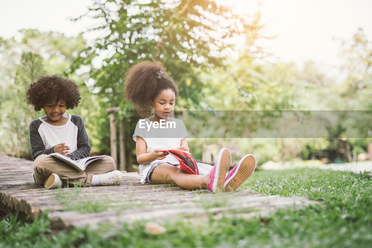 Friends studying while sitting at park