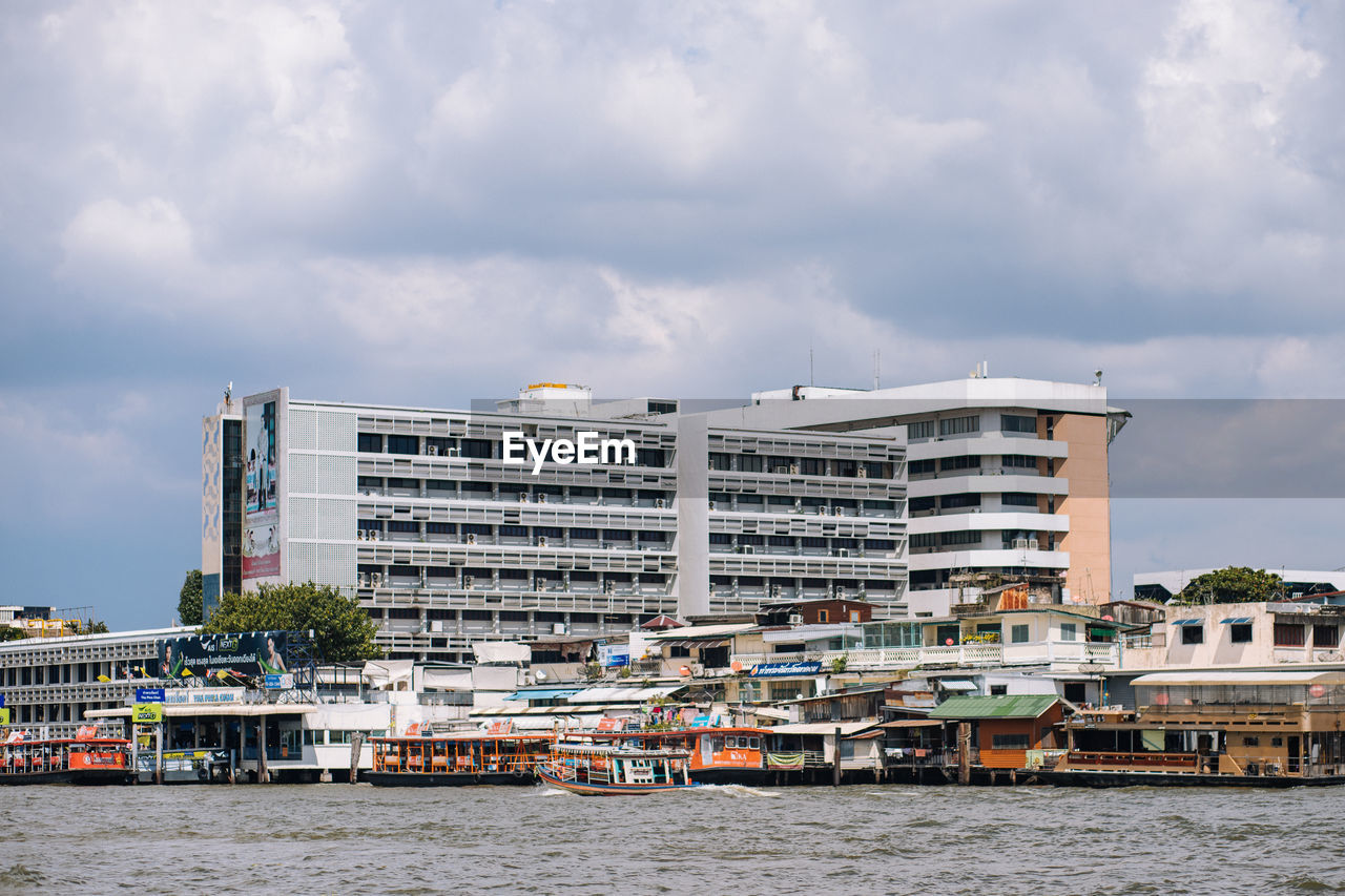 BUILDING BY RIVER AGAINST SKY