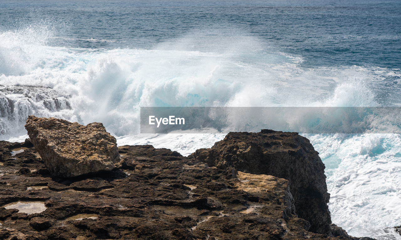 Large waves crash on the shoreline of ka'ena point on the extreme west coast of oahu in hawaii