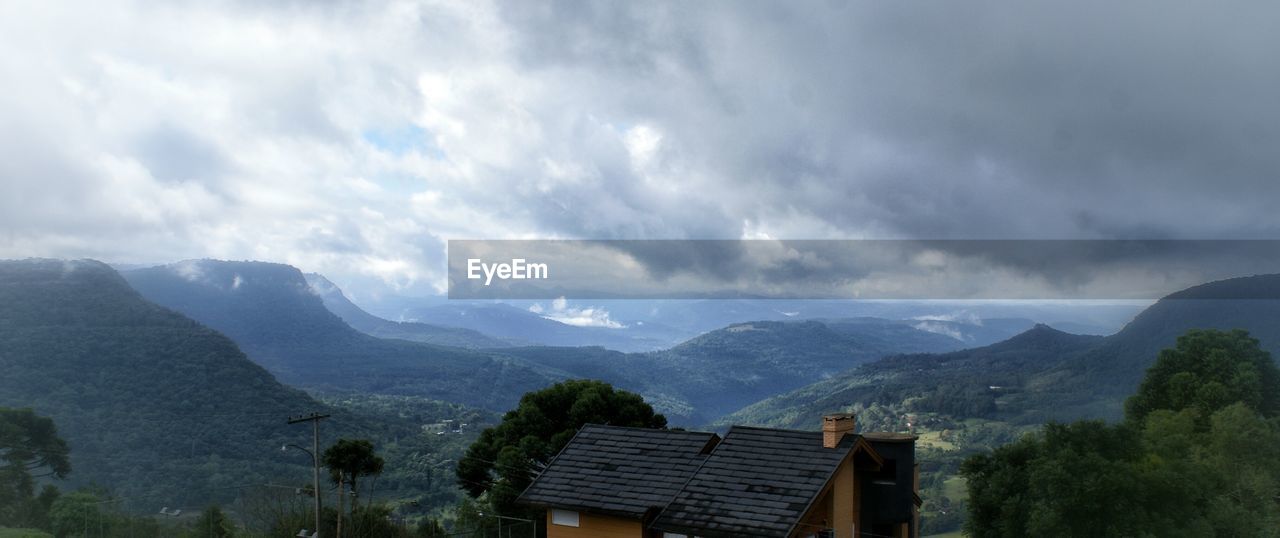 SCENIC VIEW OF MOUNTAINS AGAINST CLOUDY SKY