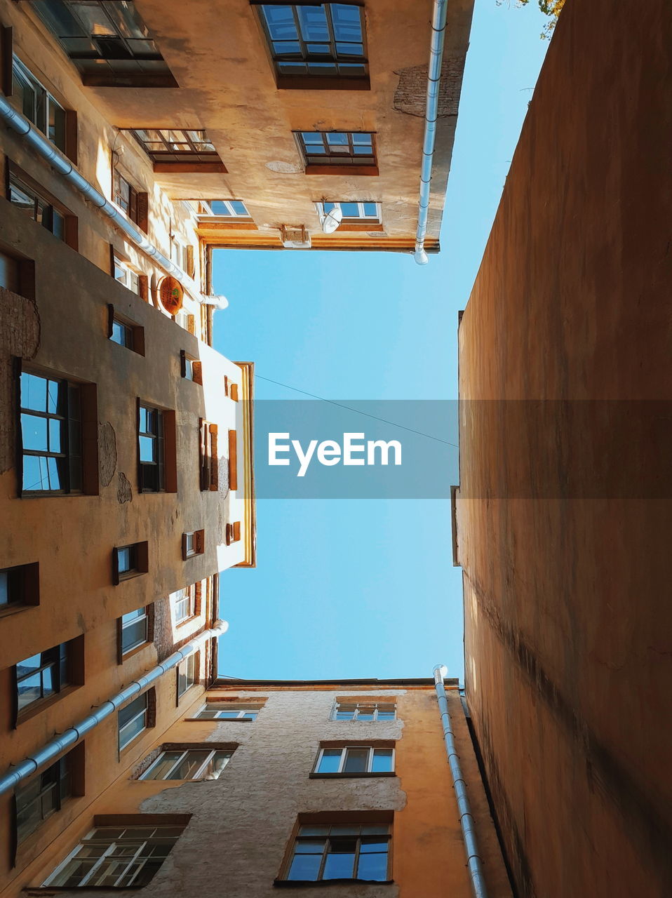 LOW ANGLE VIEW OF BUILDINGS AGAINST CLEAR BLUE SKY