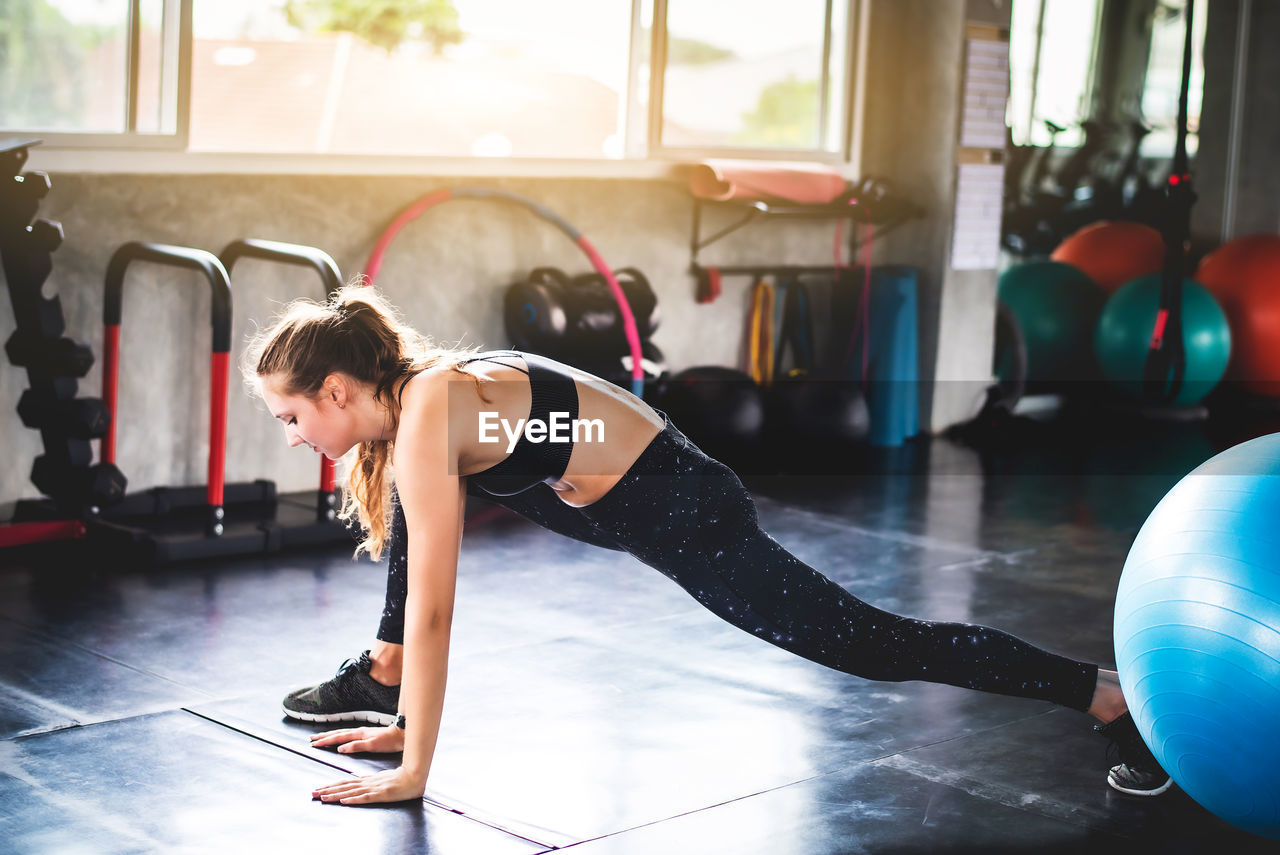 Side view of woman exercising at home