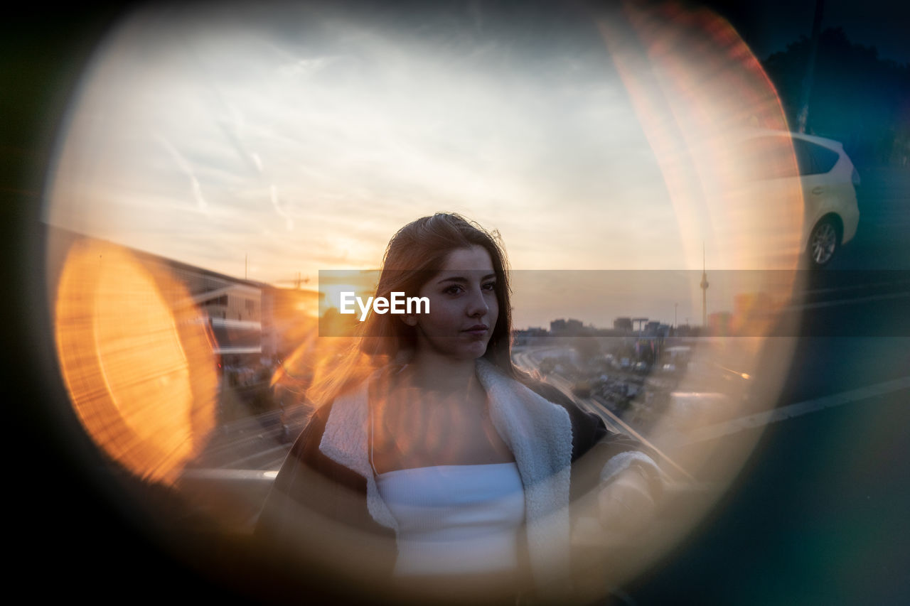 Young woman seen through equipment against sky during sunset