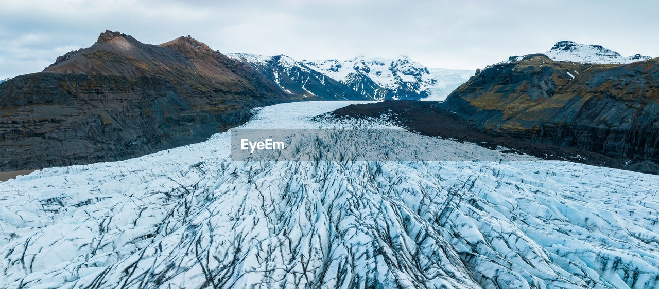 Beautiful glaciers flow through the mountains in iceland.