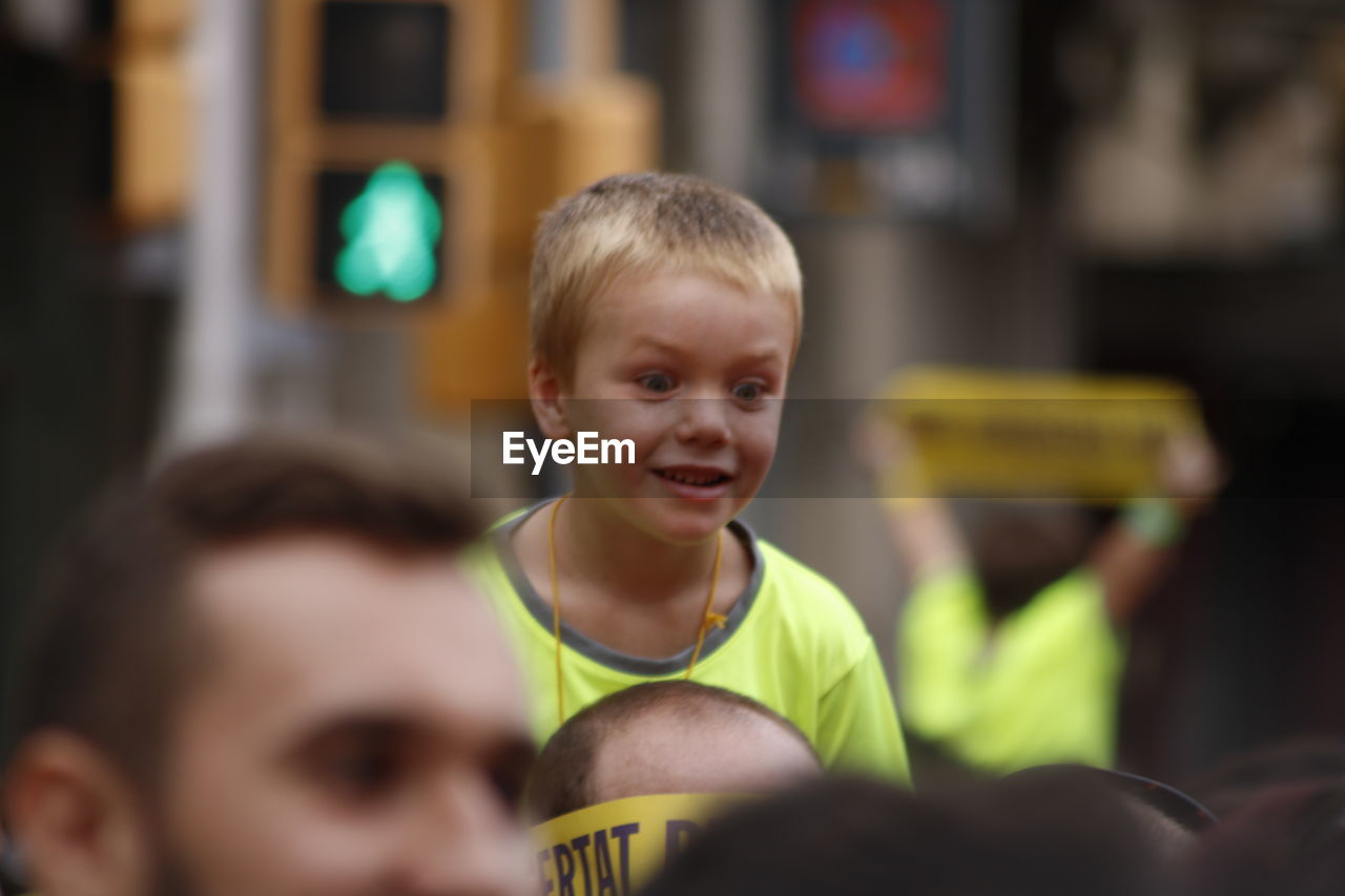 PORTRAIT OF SMILING BOY WITH ARMS OUTSTRETCHED