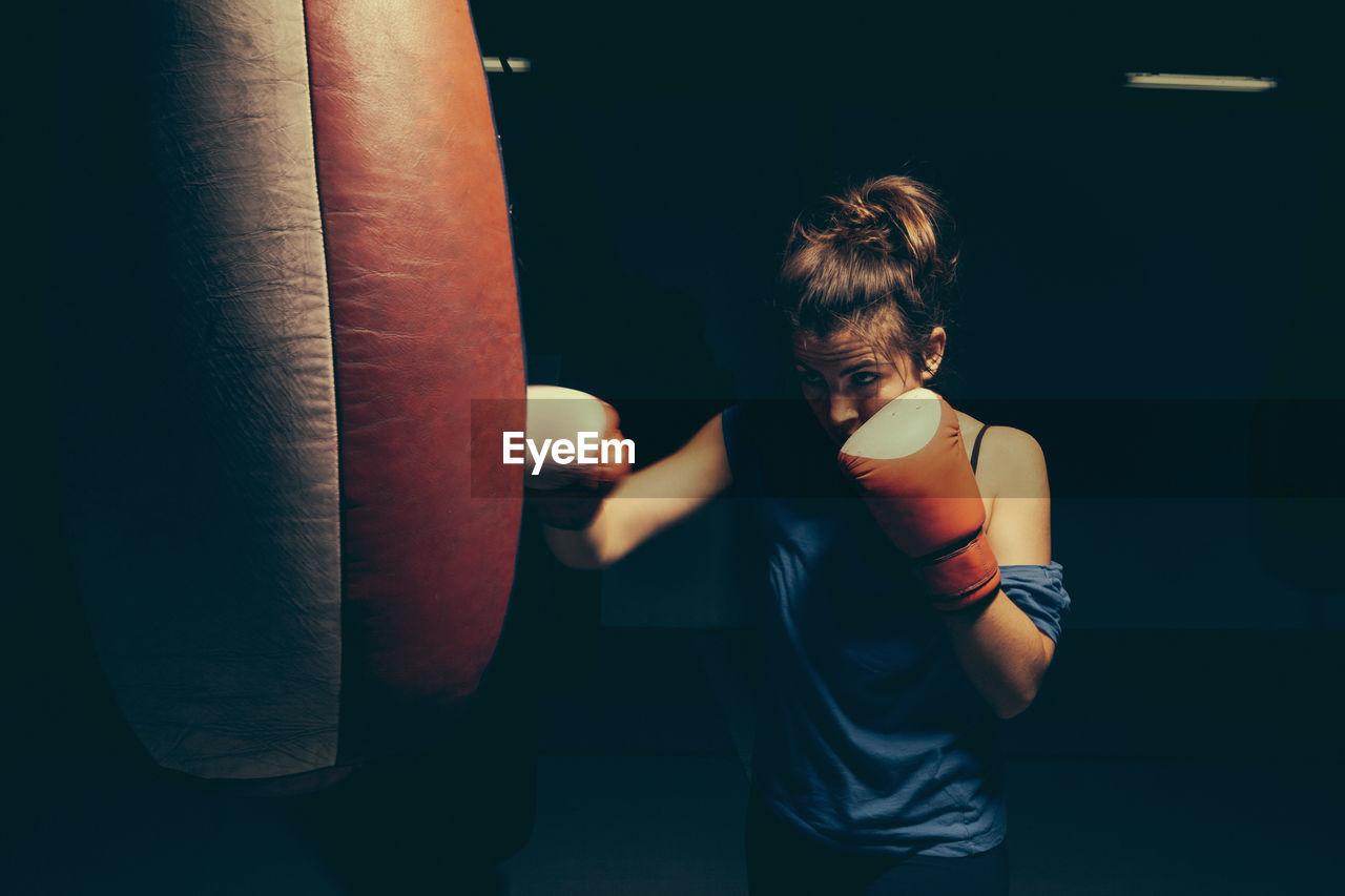 Female boxer exercising at punch bag