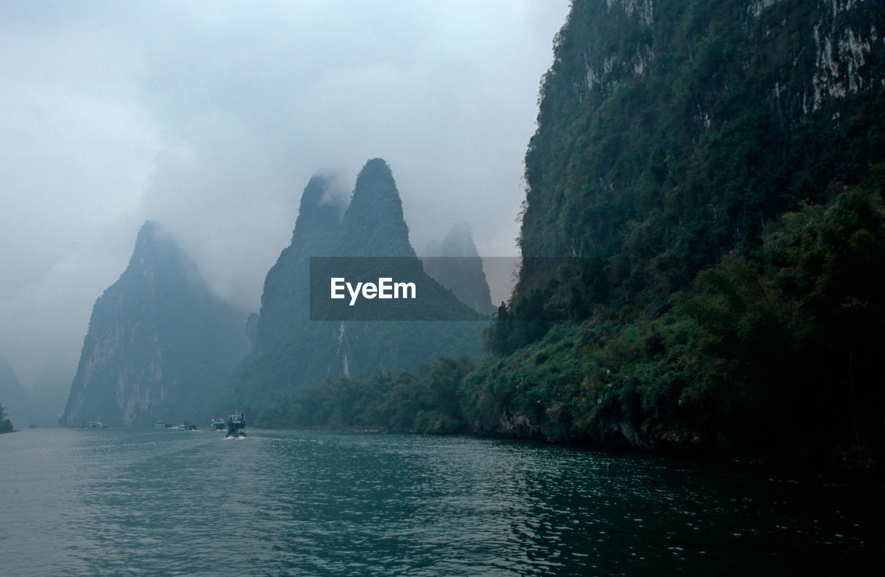 Scenic view of river and mountains against sky