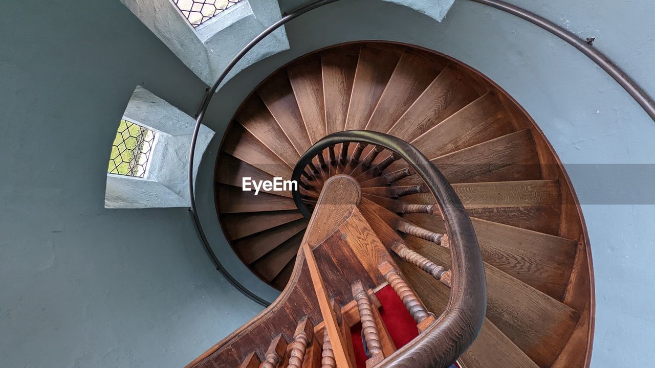 spiral staircase, staircase, steps and staircases, stairs, spiral, architecture, railing, built structure, high angle view, indoors, directly above, wood, no people, wheel, aircraft engine