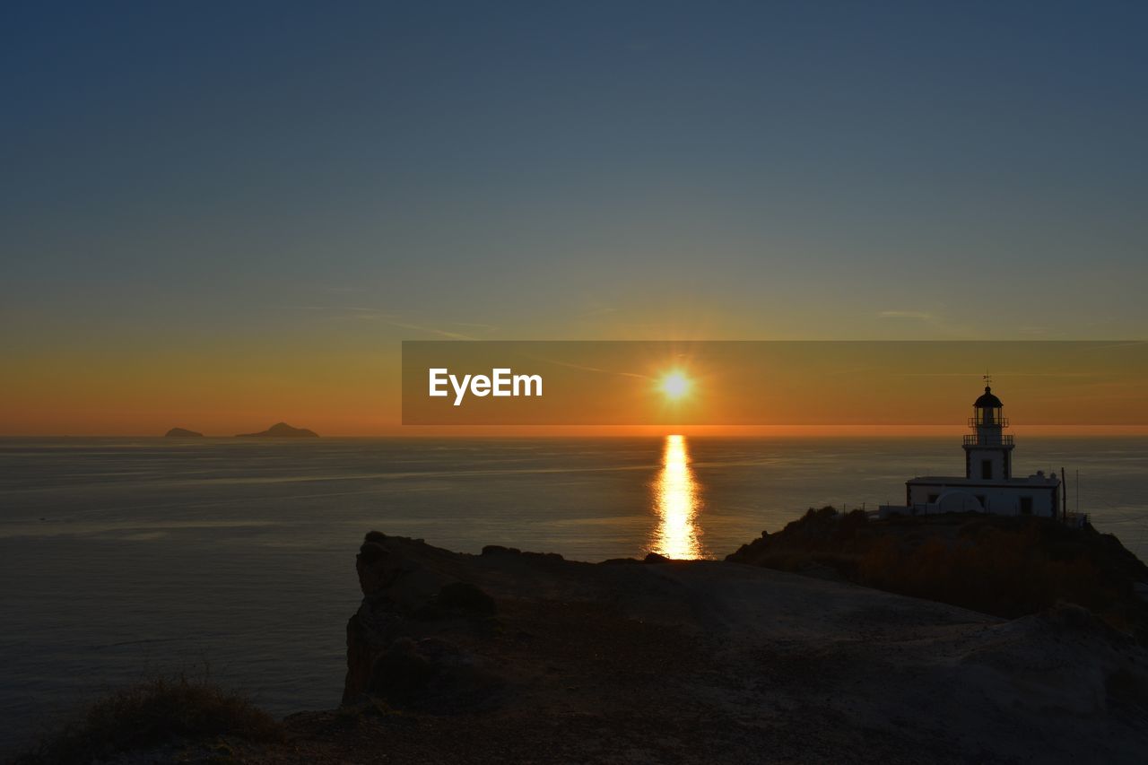 Scenic view of sea against sky during sunset. lighthouse in akrotiri, santorini, greece 