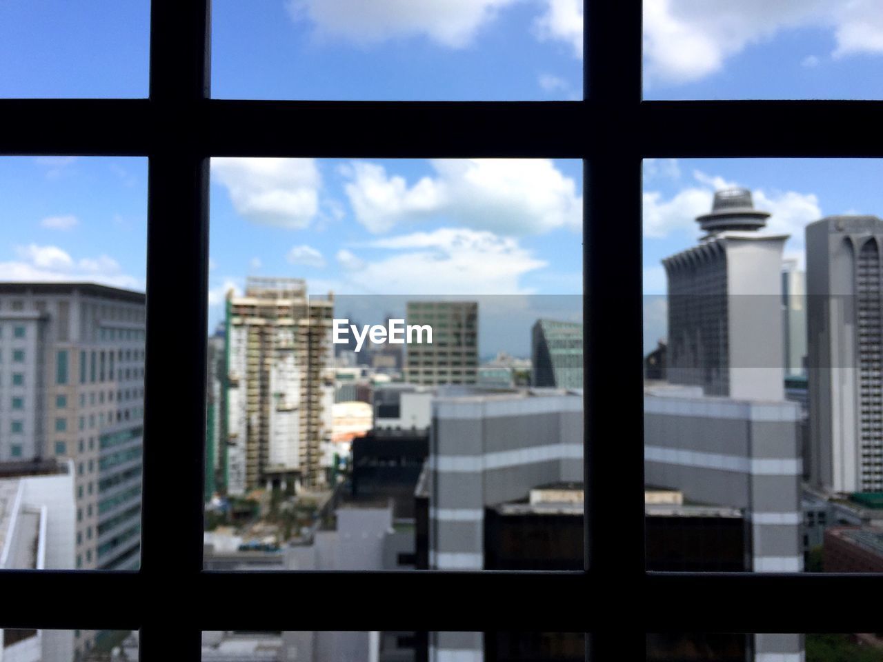 VIEW OF MODERN BUILDINGS AGAINST CLOUDY SKY