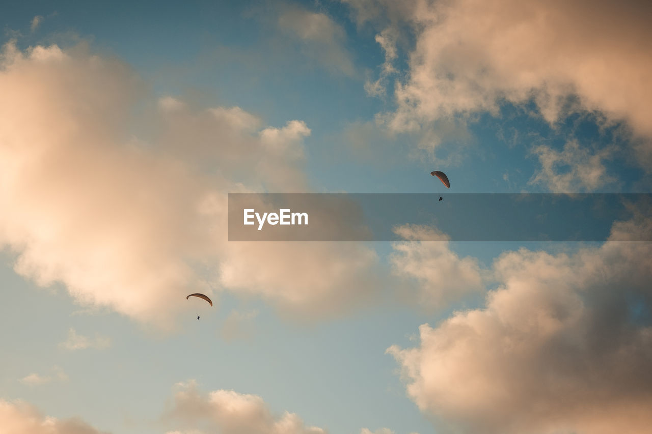 LOW ANGLE VIEW OF TWO FLYING IN SKY