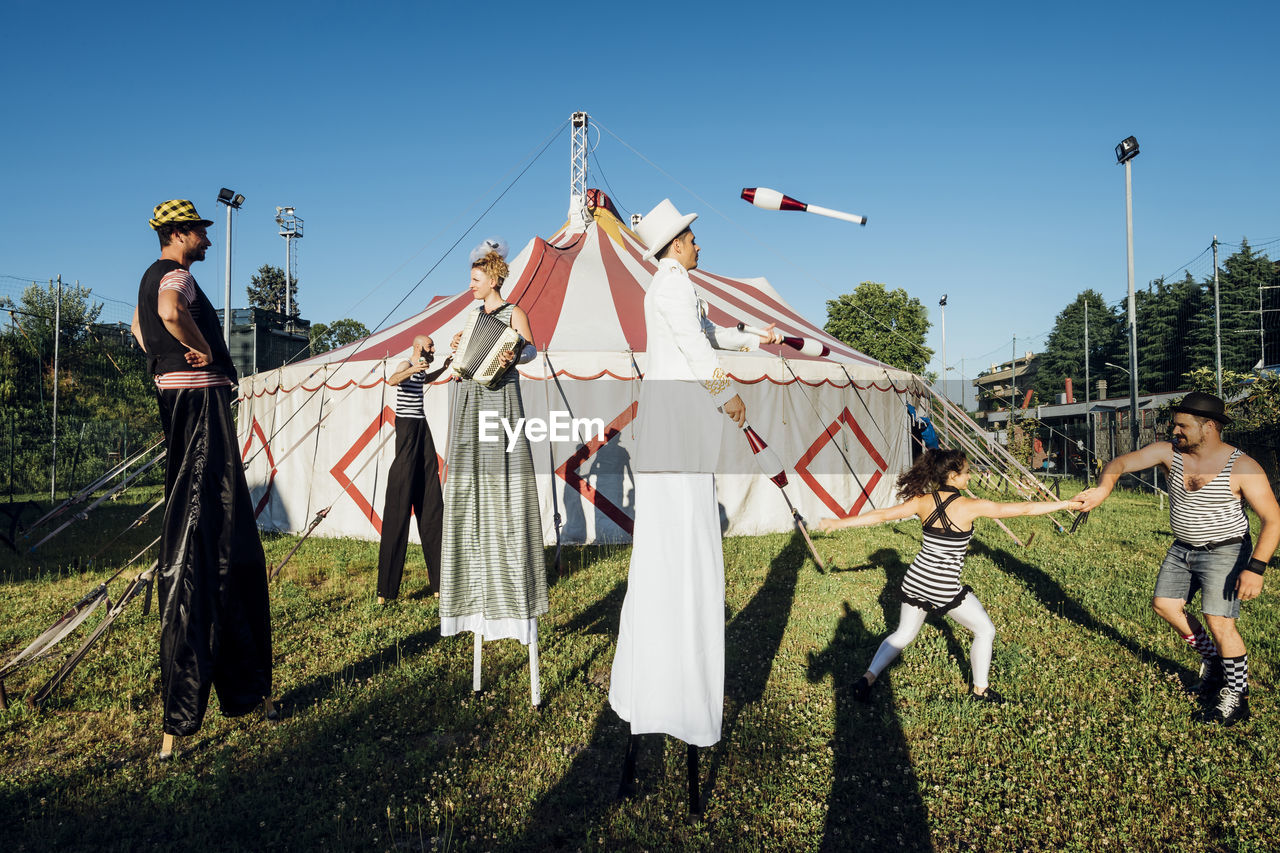 Male and female artists performing together on meadow