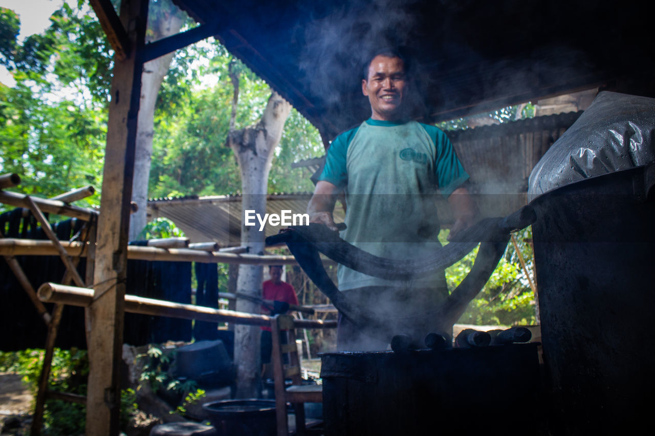  the craftsmen do  dyeing process of the fabric lurik in tringsing village,  java, indonesia