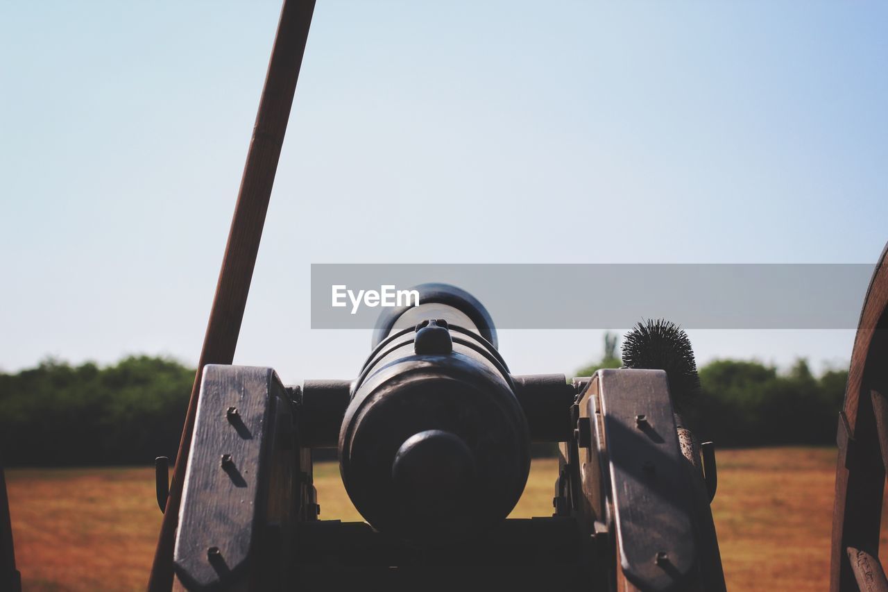 CLOSE-UP OF COIN-OPERATED BINOCULARS AGAINST SKY