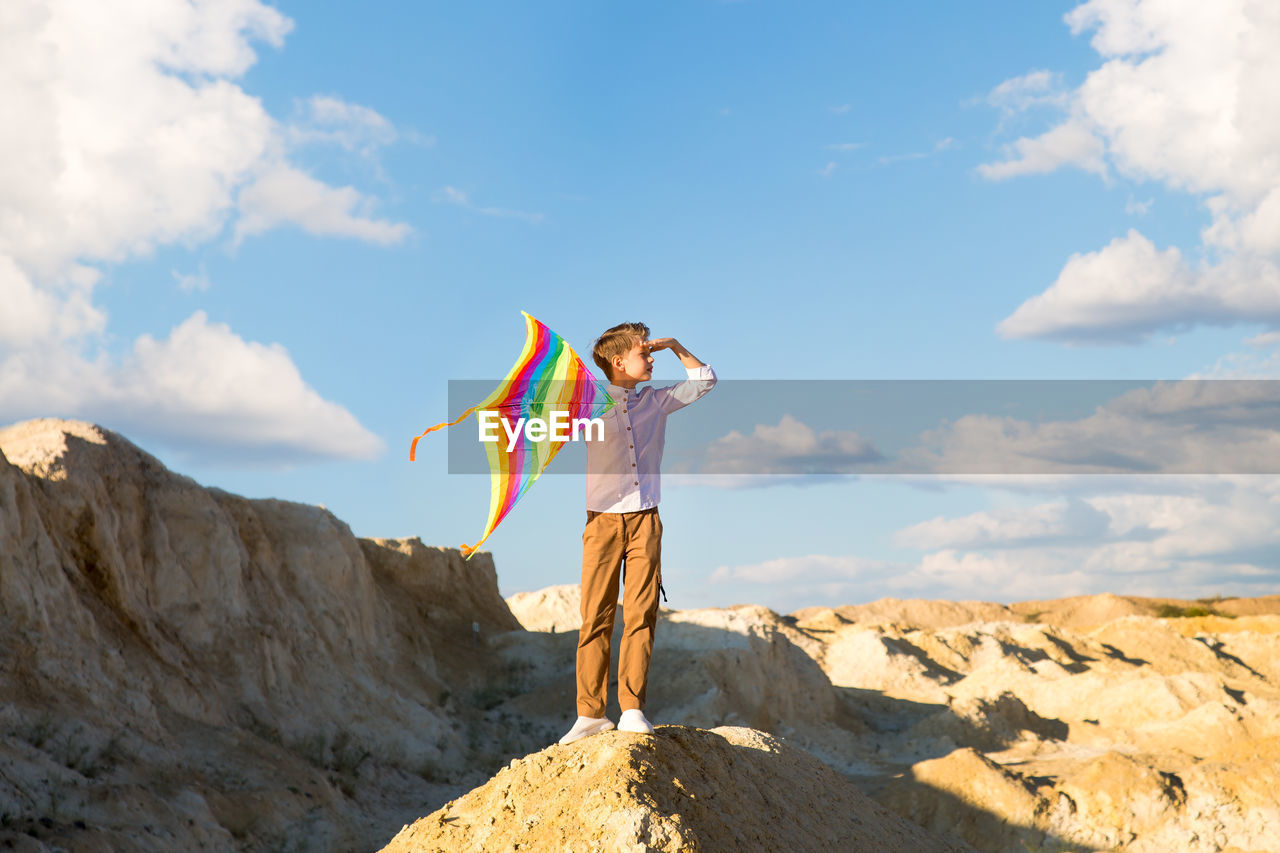 Portrait of child 8-9 years old with a kite. a blond boy stands and looks into 