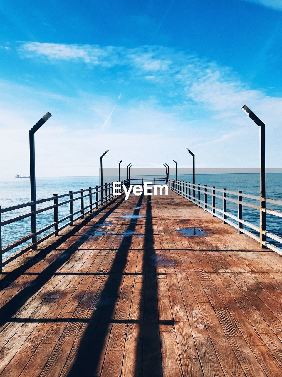 Wooden pier on sea against sky