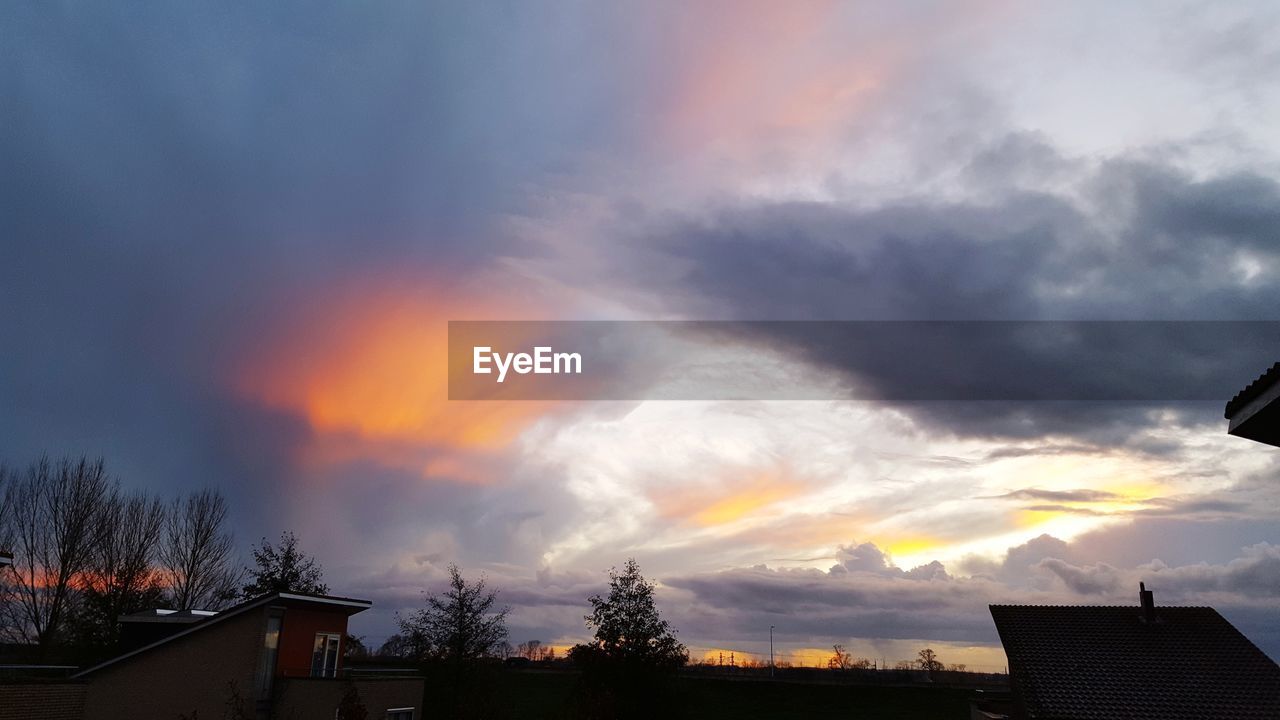 LOW ANGLE VIEW OF SILHOUETTE HOUSE AGAINST SKY DURING SUNSET