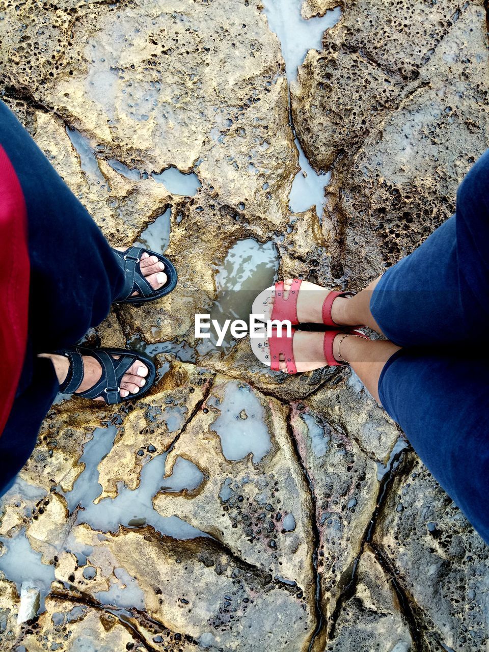 Low section of women standing on wet rock