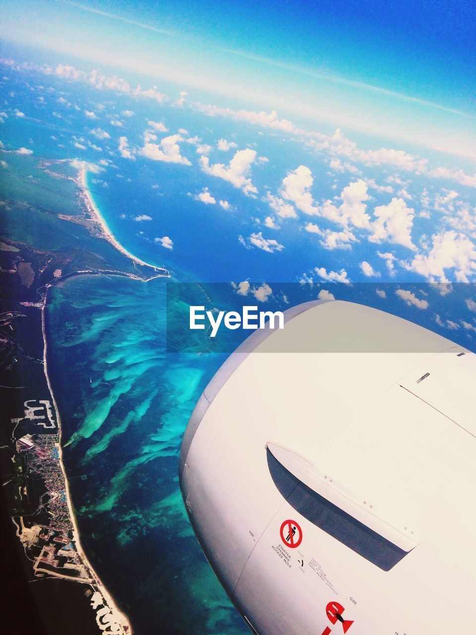 Cropped image of airplane flying over sea against sky