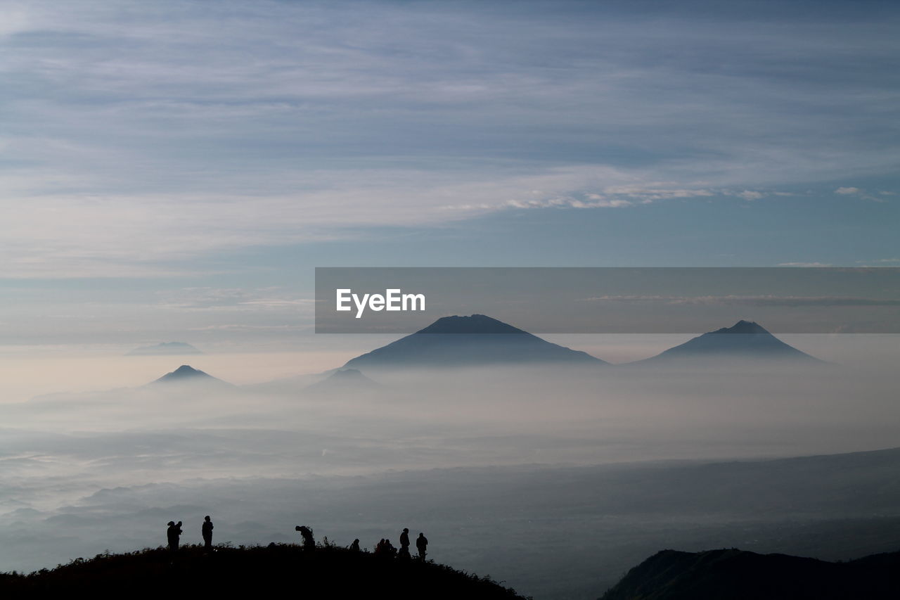 Silhouette of mountain range against cloudy sky