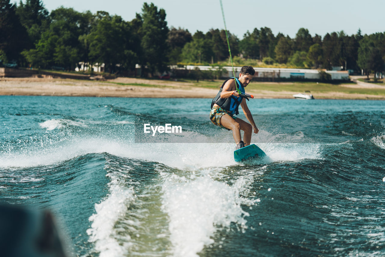 Full length of man doing wakeboard in a lake