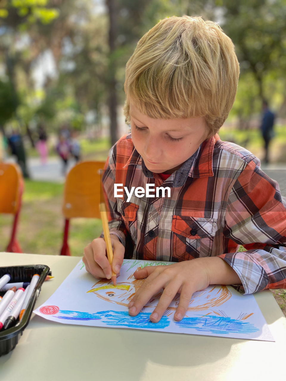 Little blond boy drawing open air lesson