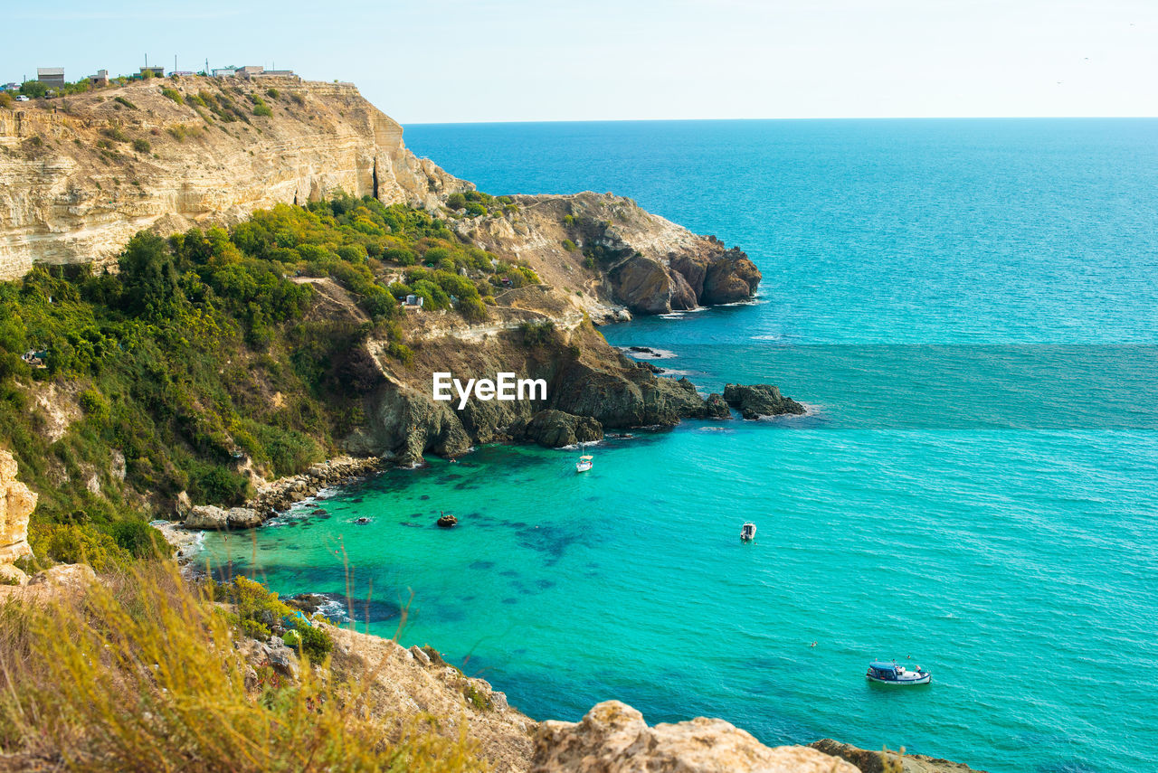 HIGH ANGLE VIEW OF ROCKS ON SEA