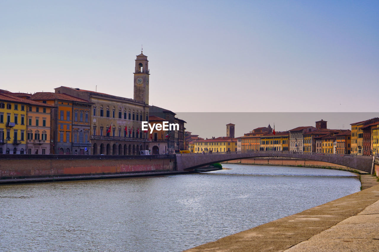 Bridge over river against buildings in city