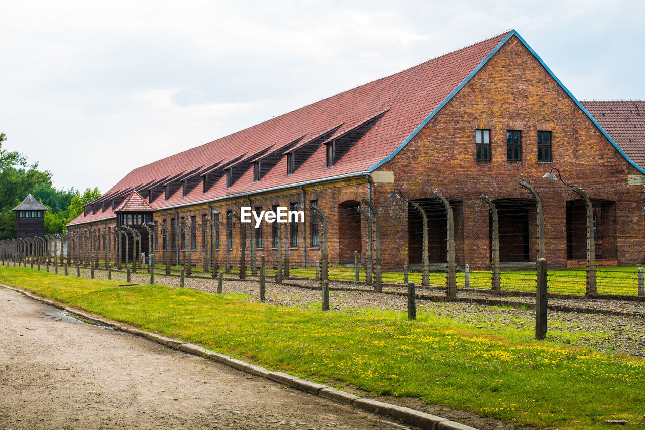 EXTERIOR OF OLD BUILDING BY HOUSE AGAINST SKY