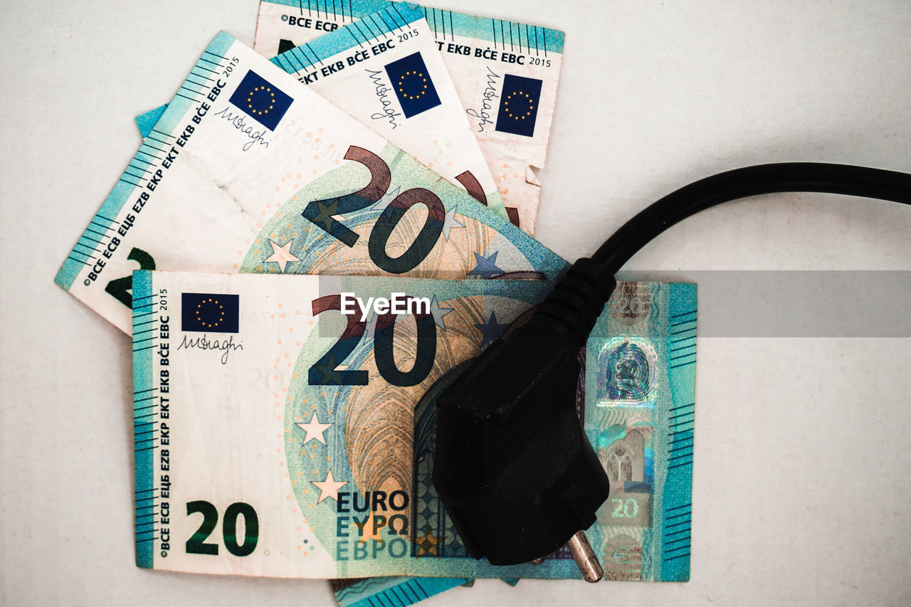 Power cable resting on top of 20 euro bills