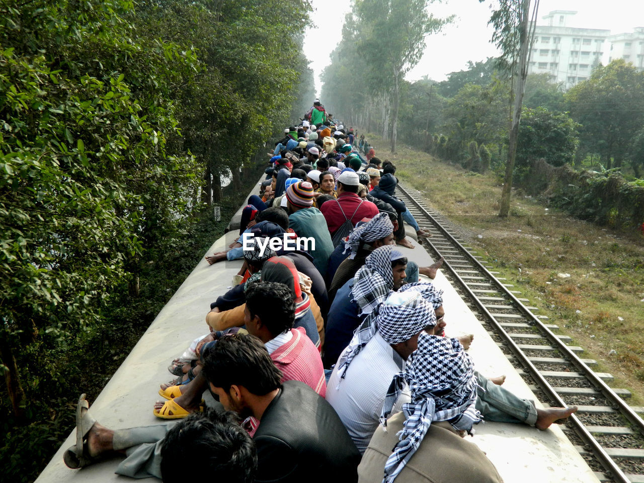 People traveling on rooftop of train