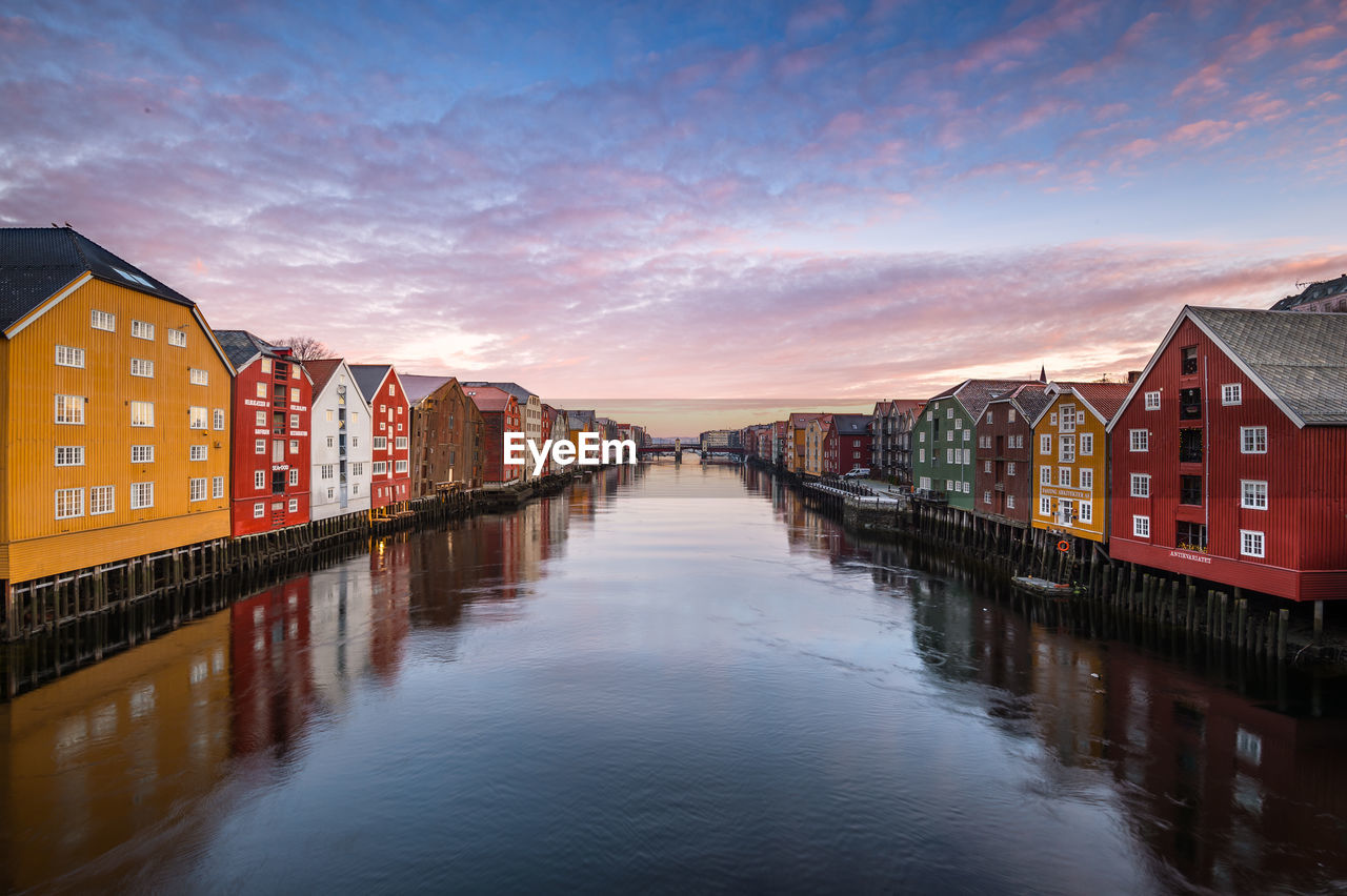 Scenic view of canal against sky at sunset