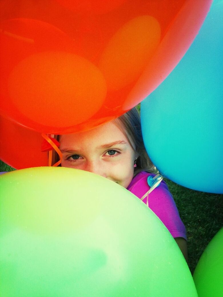 High angle view of cute girl with colorful balloons