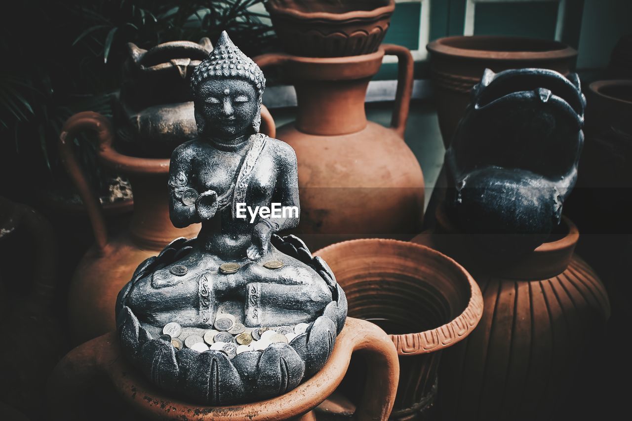 Decorative urns and statue of buddha in a store