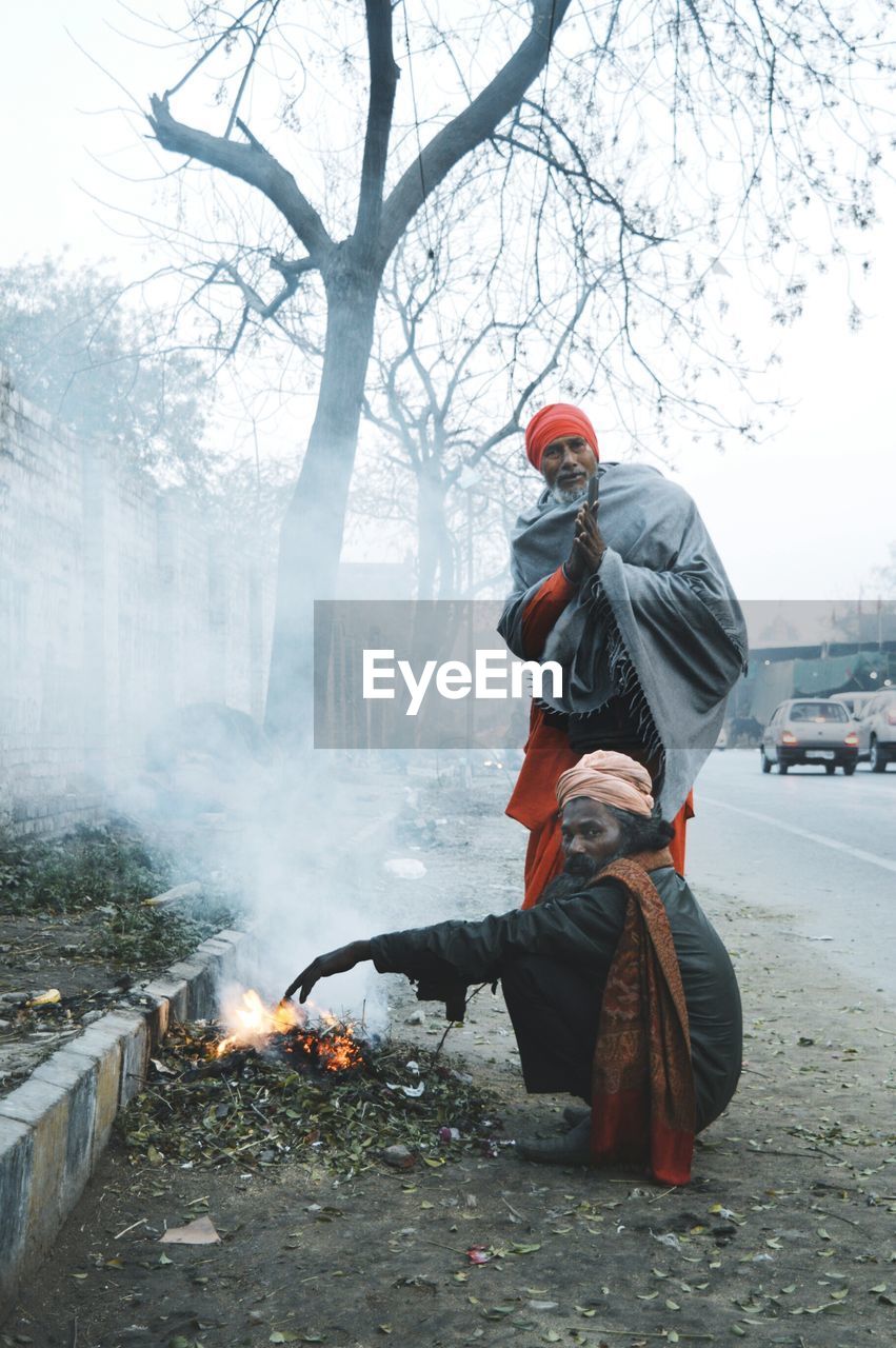 Portrait of sadhu by bonfire during winter