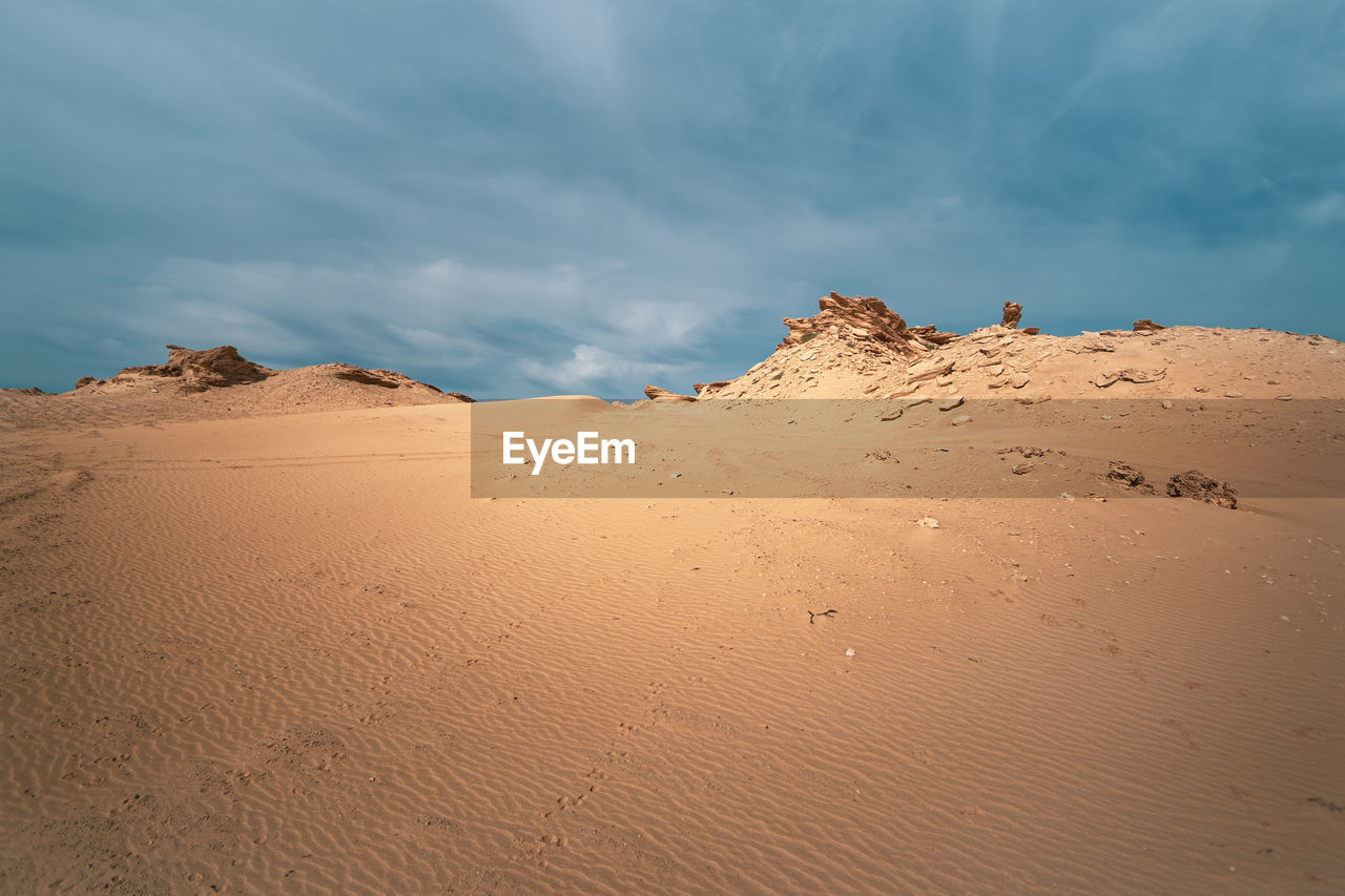 Sand dunes in desert against sky