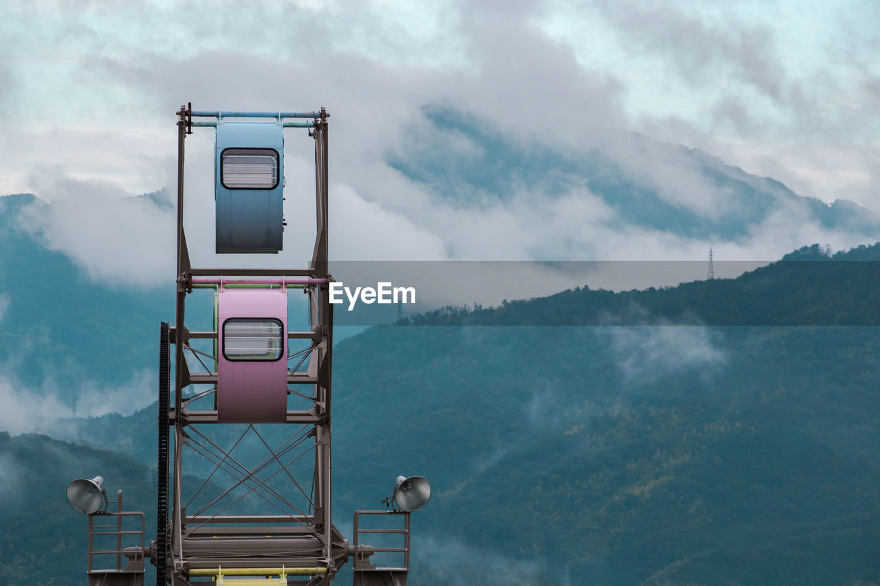 Ferris wheel against foggy mountains