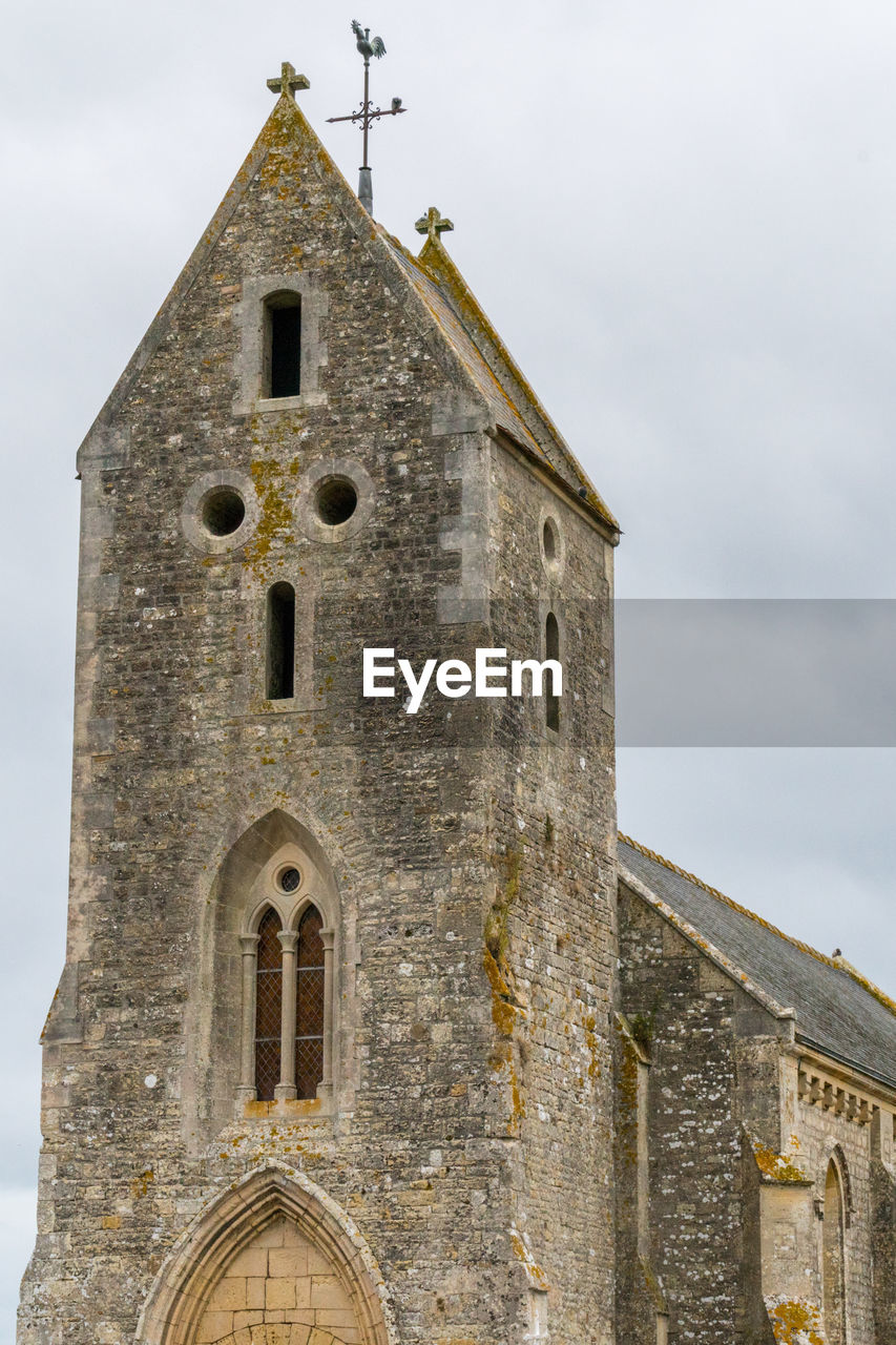 Low angle view of old a norman church against sky