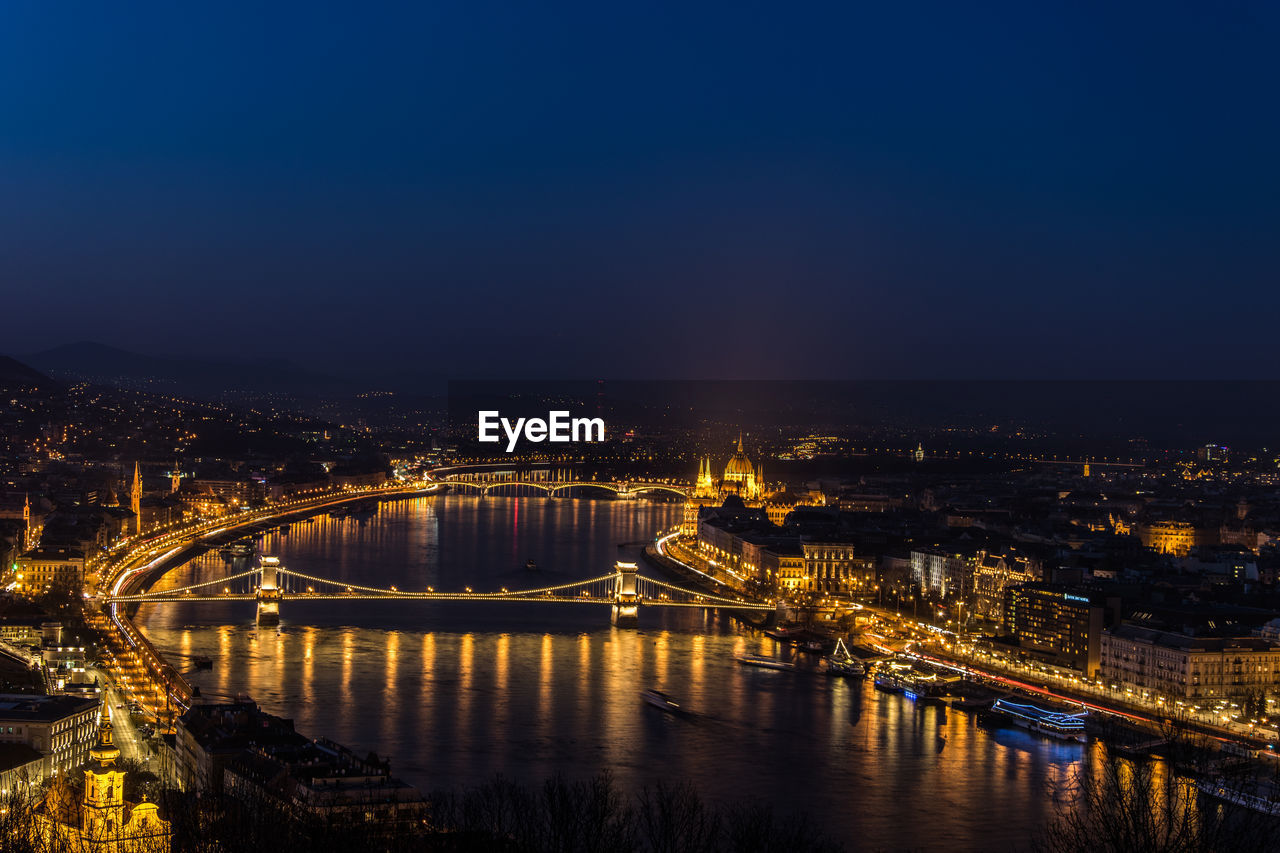 Illuminated bridge in city at night