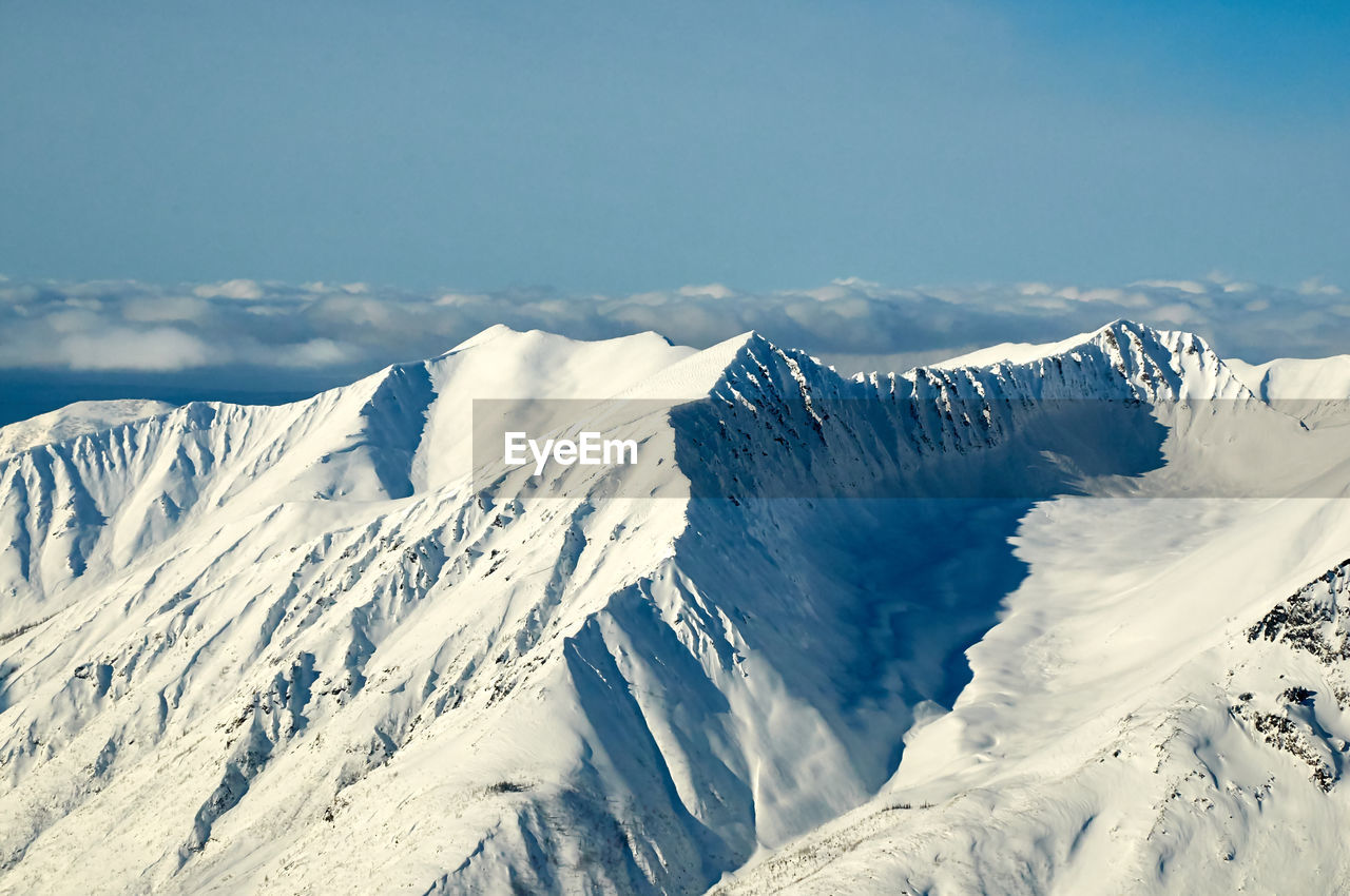 SNOW COVERED MOUNTAINS AGAINST SKY