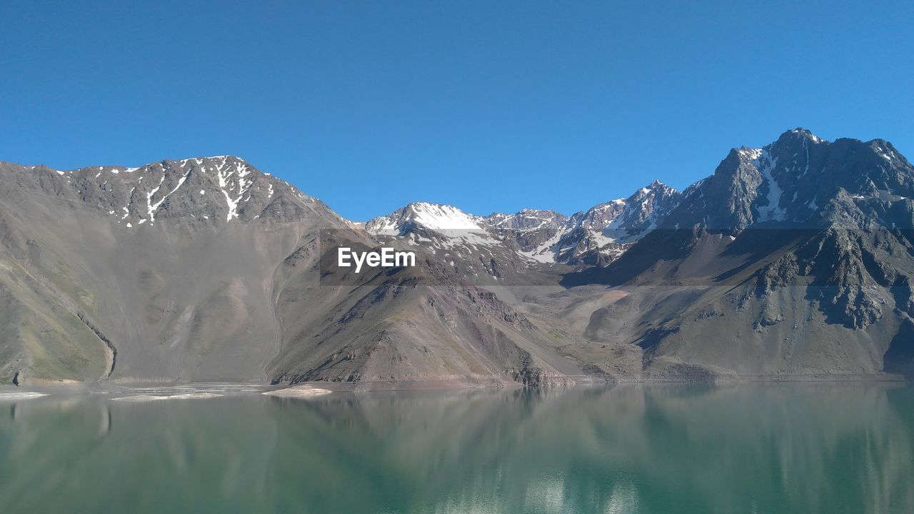 Scenic view of snowcapped mountains against clear blue sky