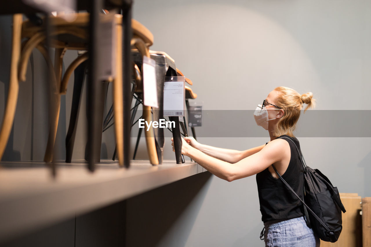 Woman wearing flu mask standing at store