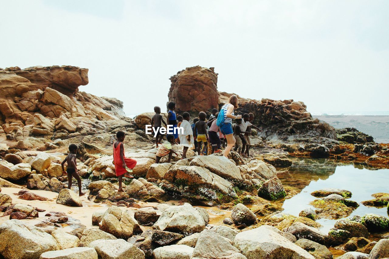 Woman and children walking on rocks at beach