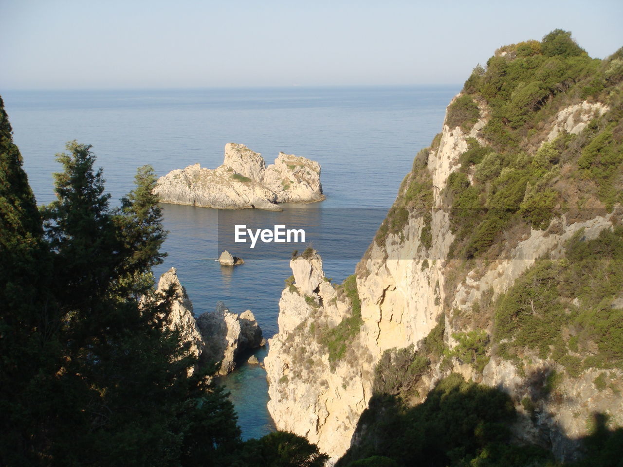 Scenic view of mountain at sea shore against sky